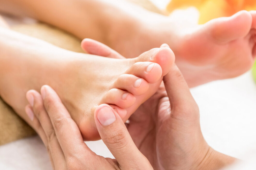 Professional therapist giving reflexology Thai foot massage to a reflexology zonetherapy the original ingham method